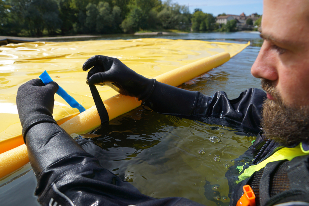 Technicien fixant les flotteurs du batardeau Water-Gate avec velcro